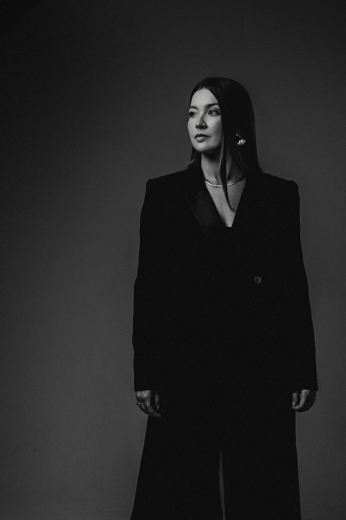 Retrato em preto e branco, mulher em terno preto de perfil